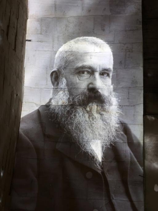 Eine Fotografie des französischen Malers Claude Monet an eine weiße Wand projeziert