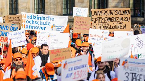 Menschen nehmen an einer Demonstration von Uniklinik-Ärzten teil.