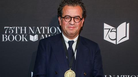 Der Autor Hisham Matar bei der Zeremonie der 75. National Book Awards im Novemeber 2024: Er steht vor einer schwarzen Wand mit dem Logo des Awards (Foto von Andy Kropa/Invision/AP) Der Autor Hisham Matar bei der Zeremonie der 75. National Book Awards im Novemeber 2024: Er steht vor einer schwarzen Wand mit dem Logo des Awards (Foto von Andy Kropa/Invision/AP)