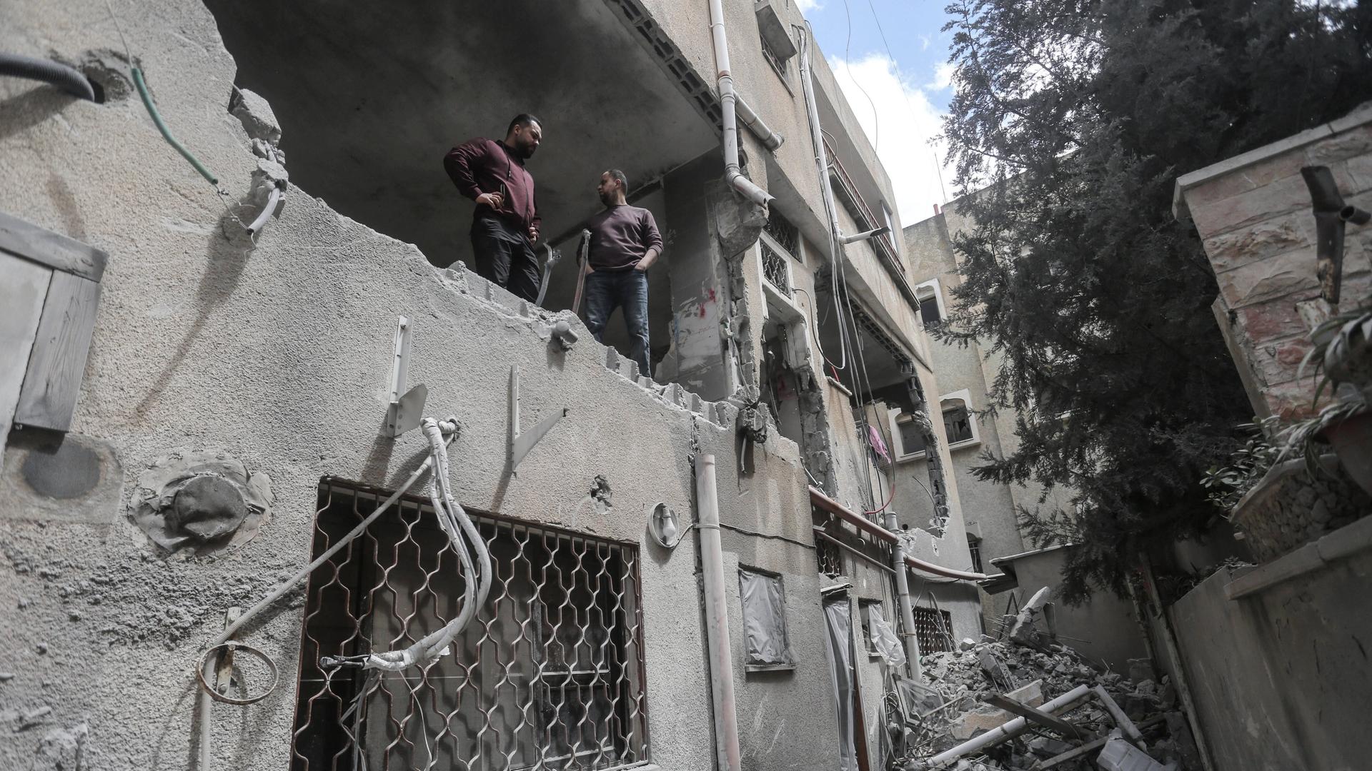 Zwei Männer stehen im ersten Stock eines Gebäudes, an dem israelische Soldaten große Schäden angerichtet haben. Zwei Männer stehen im ersten Stock eines Gebäudes, an dem israelische Soldaten große Schäden angerichtet haben.