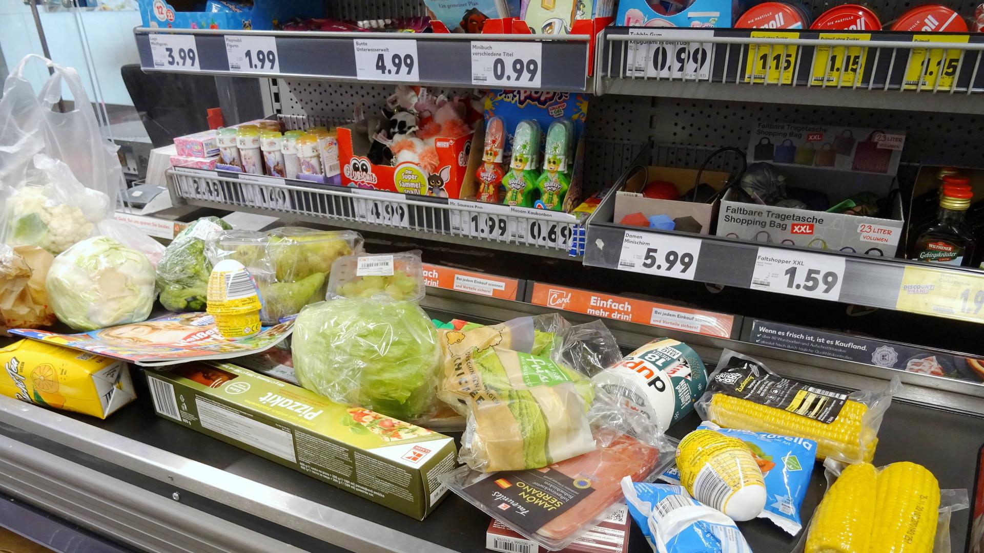 Auf einem Band im Supermarkt liegen verschiedene Lebensmittel.