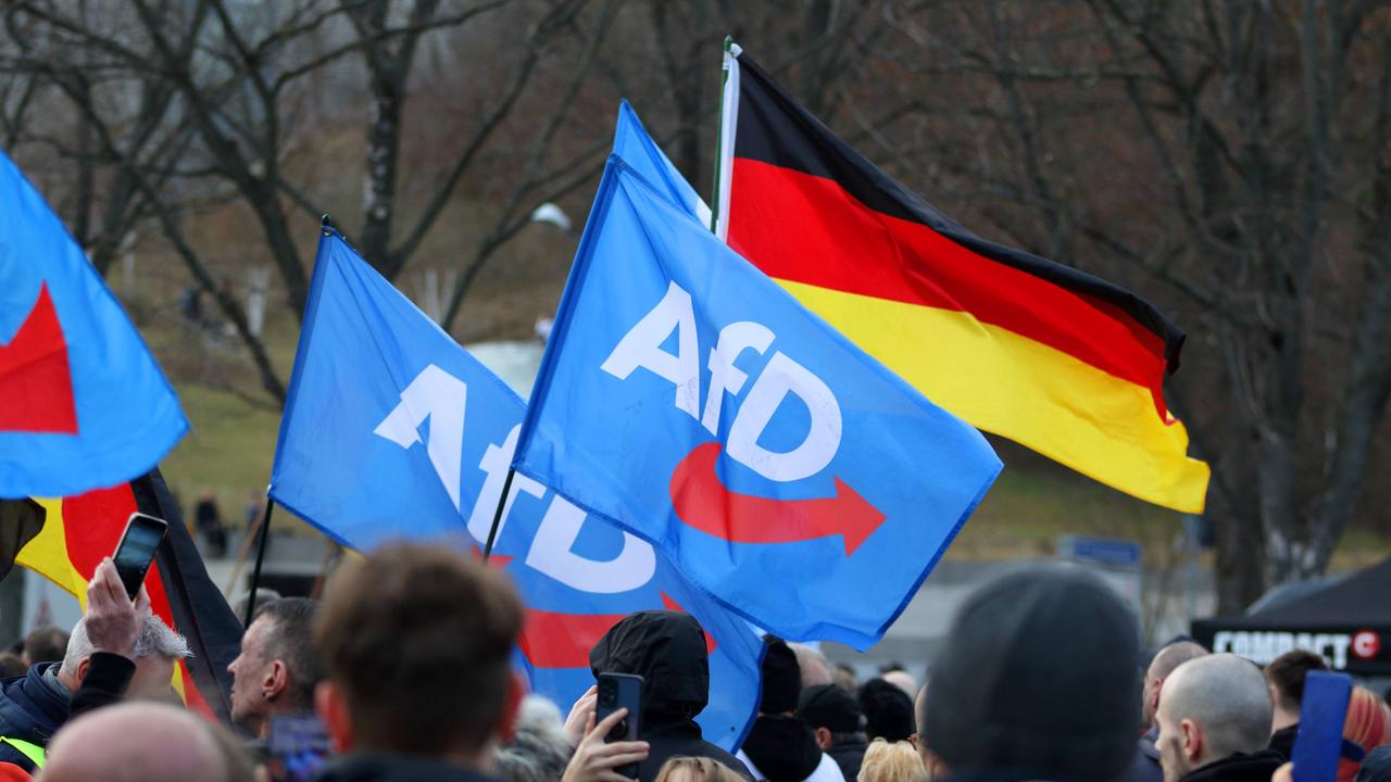 Anhänger mit AfD-Fahnen und Deutschlandflaggen vor der Haupbühne der AfD-Abschlusskundgebung zur Bundestagswahl im Februar 2025 auf dem Erfurter Domplatz.