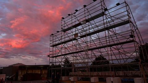 Vor dem roten Abendhimmel hebt sich ein großes Gerüst ab, an dem zuvor ein Kunstwerk hing.