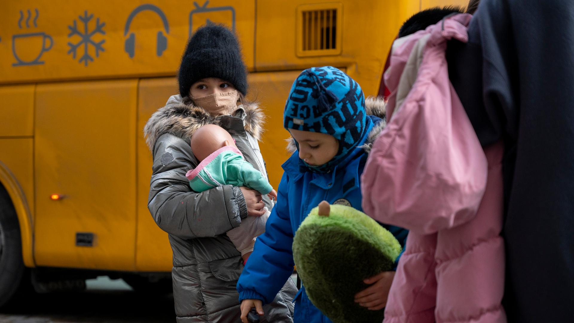 Kinder aus Odessa stehen nach ihrer Ankunft in Berlin vor einem Bus.