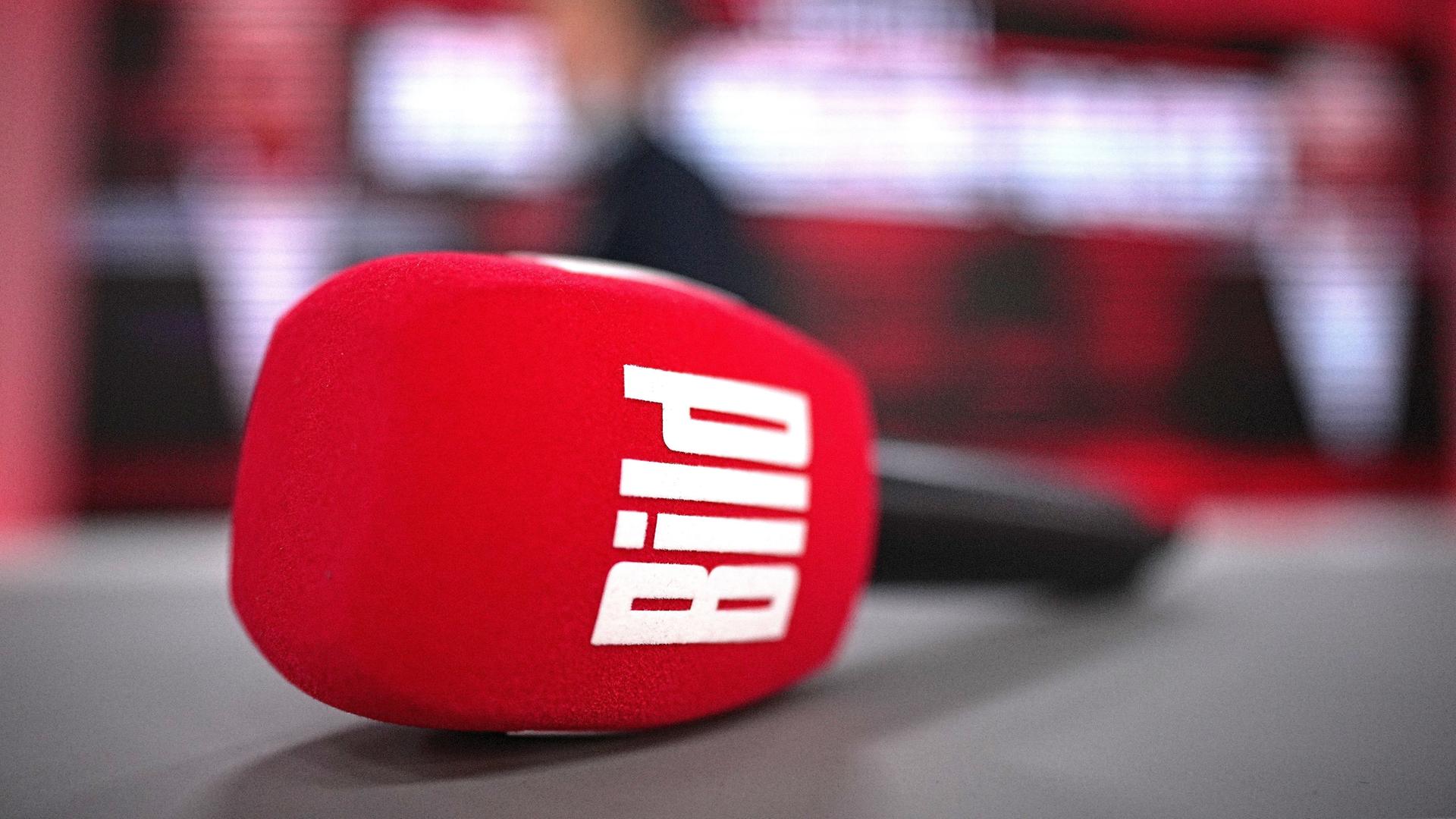 Ein Mikrofon mit dem Logo von „Bild“ liegt auf einem Tresen 