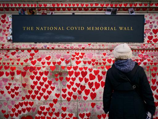 Es gibt Orte, die die Opfer von Corona unübersehbar machen: Jedes Herz steht für einen Menschen, der am Virus verstorben ist. Angehörige haben die Namen auf der Mauer gegenüber Westminister in London verewigt. Öffentliches Gedenken und Erinnern an zigtausend Opfer. 
