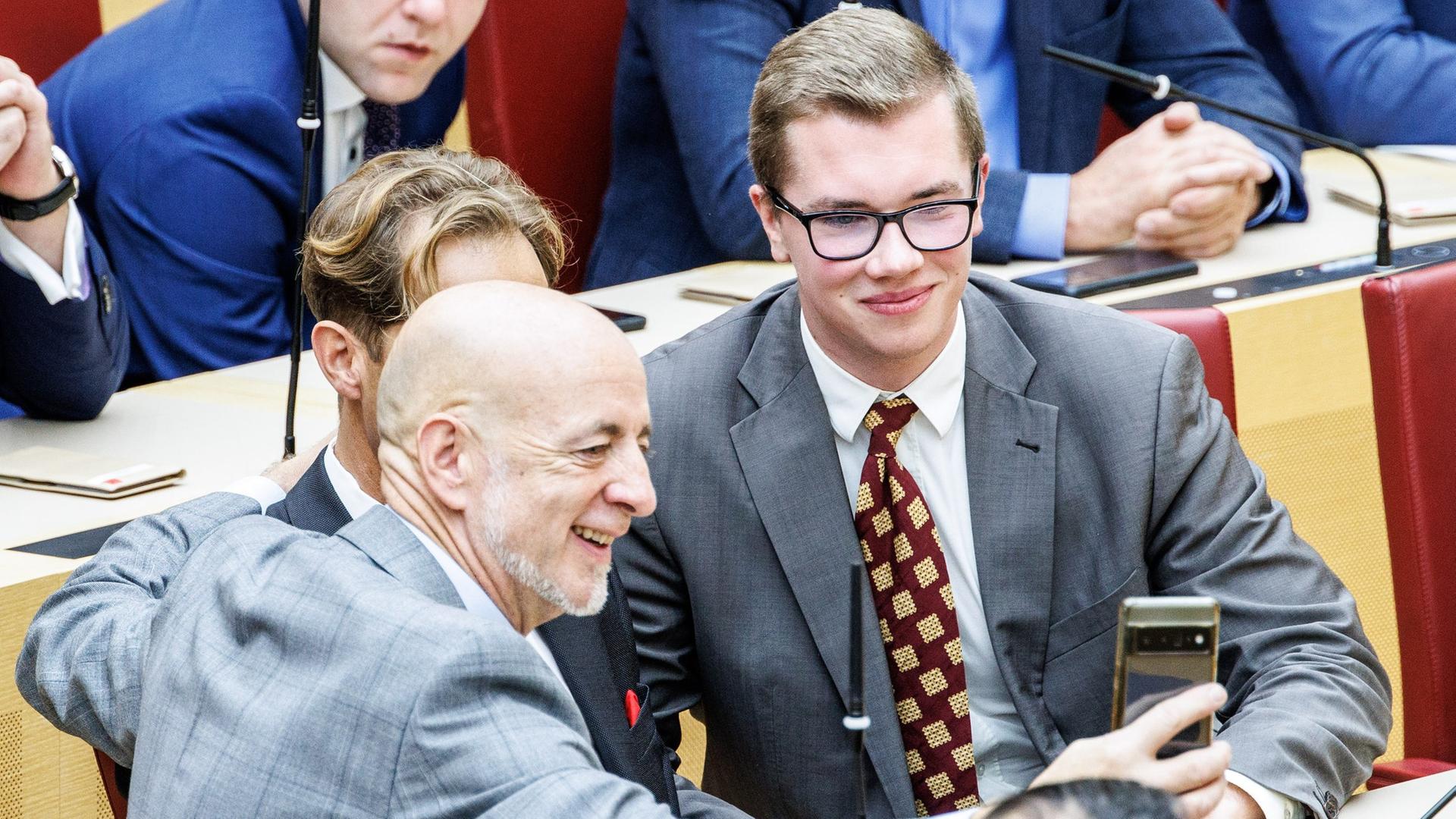 Martin Böhm (AfD, l-r) nimmt zu Beginn der zweiten Plenarsitzung des bayerischen Landtags in der Mitte der Fraktion der Alternative für Deutschland ein Selfie mit Ingo Hahn und Daniel Halemba auf.