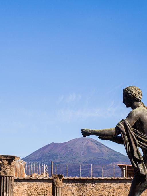 Statue des Apollo in der antike Stadt, Pompeji, Kampanien,. Im Hintergrund der Vulkan Vesuv