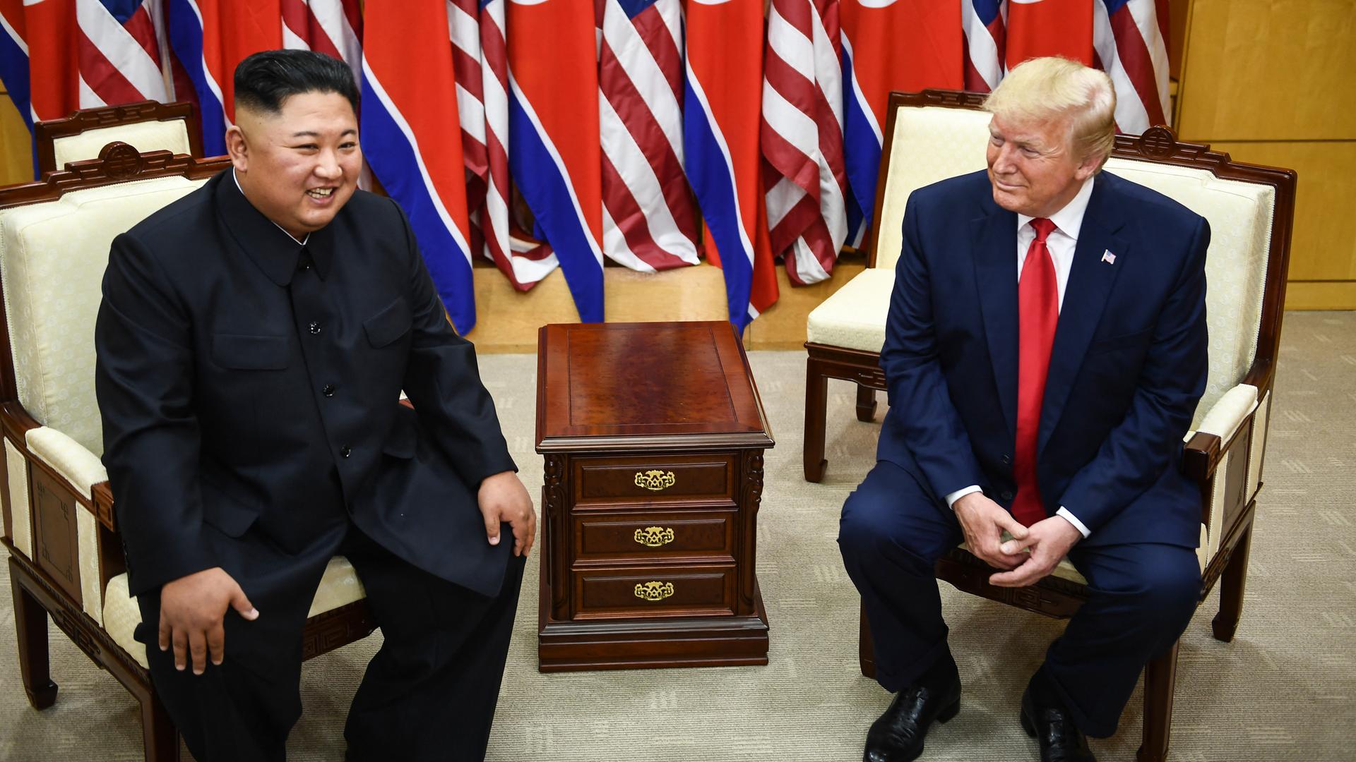 Kim Jong Un und Donald Trump sitzen bei einem Treffen im Juni 2019 in Sesseln. Im Hintergrund sind Flaggen Nordkoreas und der USA. Kim Jong Un und Donald Trump sitzen bei einem Treffen im Juni 2019 in Sesseln. Im Hintergrund sind Flaggen Nordkoreas und der USA.