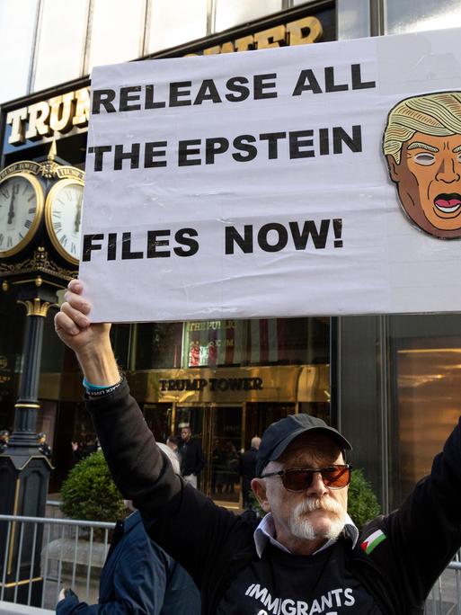 Ein Anti-Trump-Demonstrant steht in New York mit einem Plakat in der Hand auf dem steht: "RELEASE ALL THE EPSTEIN FILES NOW!' (Jatzt alle Epstein-Akten veröffentlichen) 