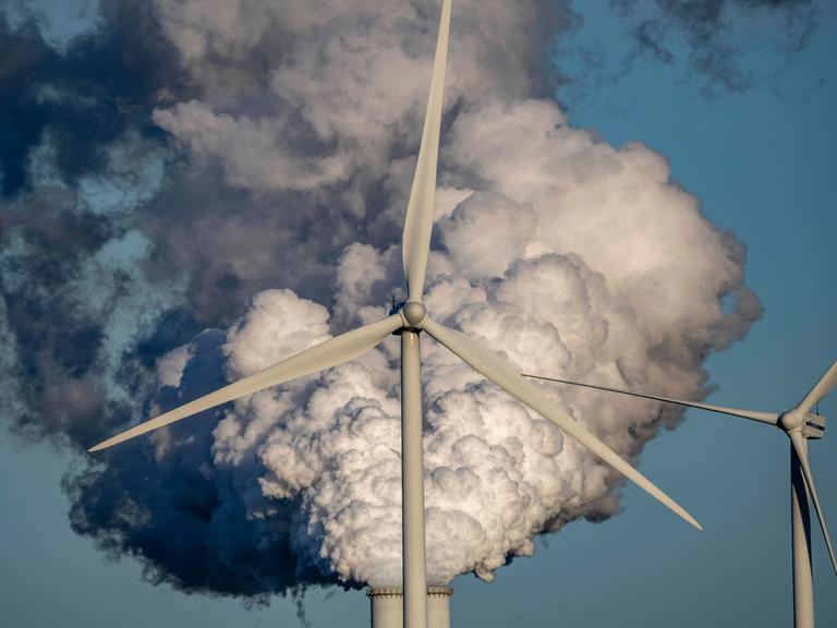 Schornsteine und Rauch des RWE Kohlekraftwerks Eemshavencentrale mit Windrädern