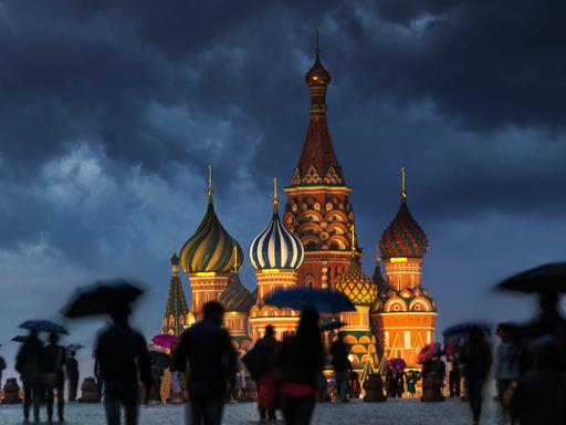 Menschen auf dem Roten Platz in Moskau an einem verregneten Abend.