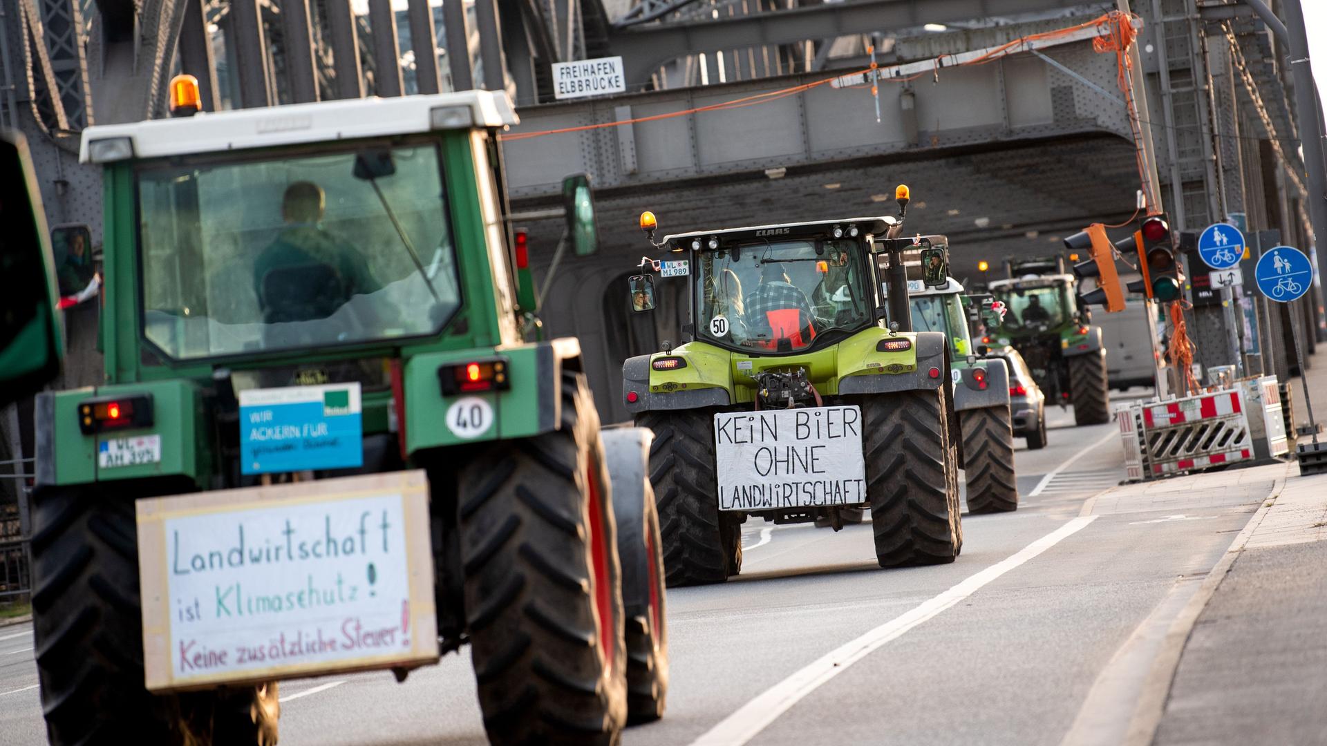 Hamburg: Traktoren mit Schildern mit der Aufschrift "Landwirtschaft ist Klimaschutz! Keine zusätzliche Steuer" und "Kein Bier ohne Landwirtschaft" fahren über die Freihafenelbbrücke.