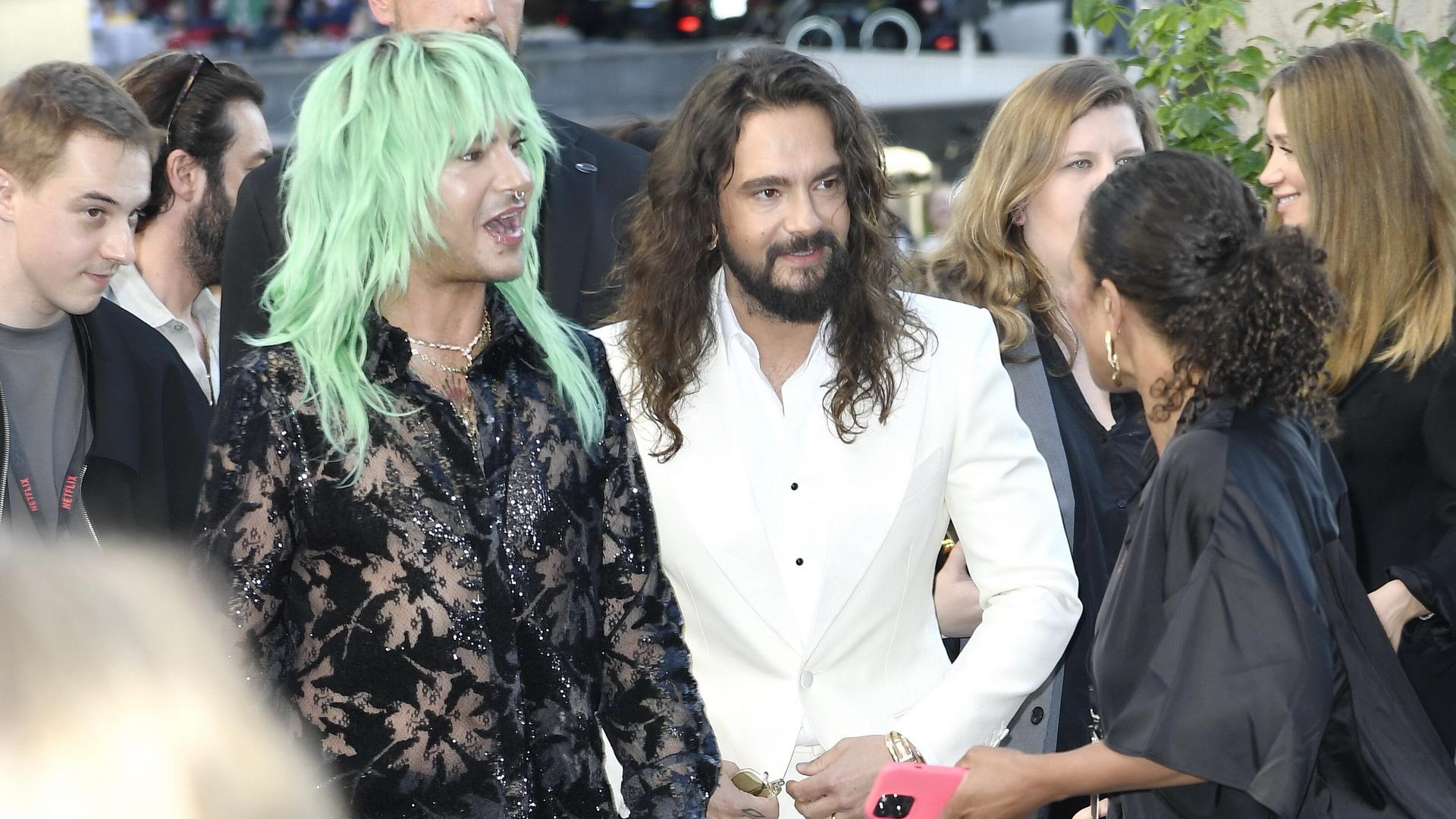 Die Brüder und Musiker der Band Tokio Hotel, Bill und Tom Kaulitz, stehen auf einem roten Teppich und sprechen mit Reportern.