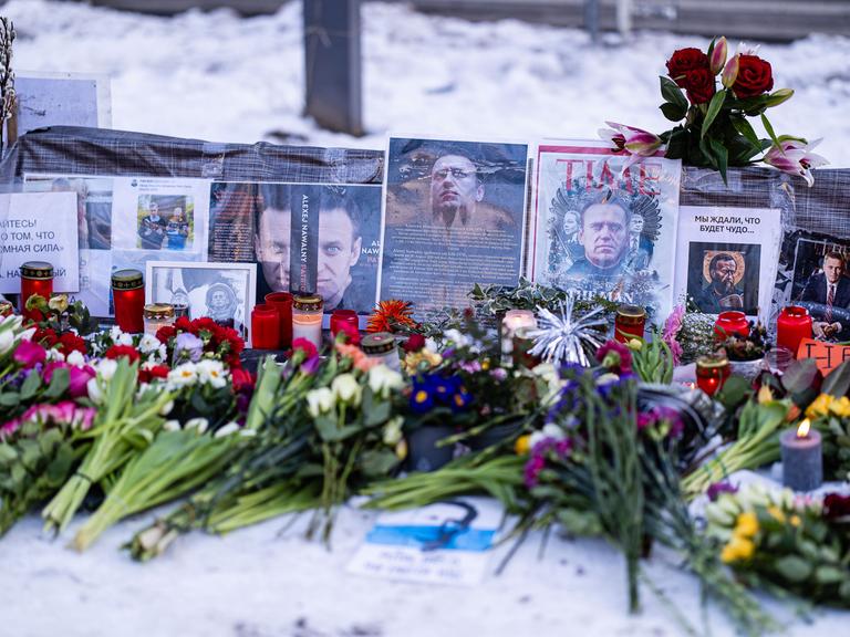 Blumen und Fotos bei einem Gedenk zu Alexej Nawalny am 16. Februar 2025 vor der Russischen Botschaft in Berlin. Der russische Jurist und Oppositionspolitiker ist vor einem Jahr gestorben.