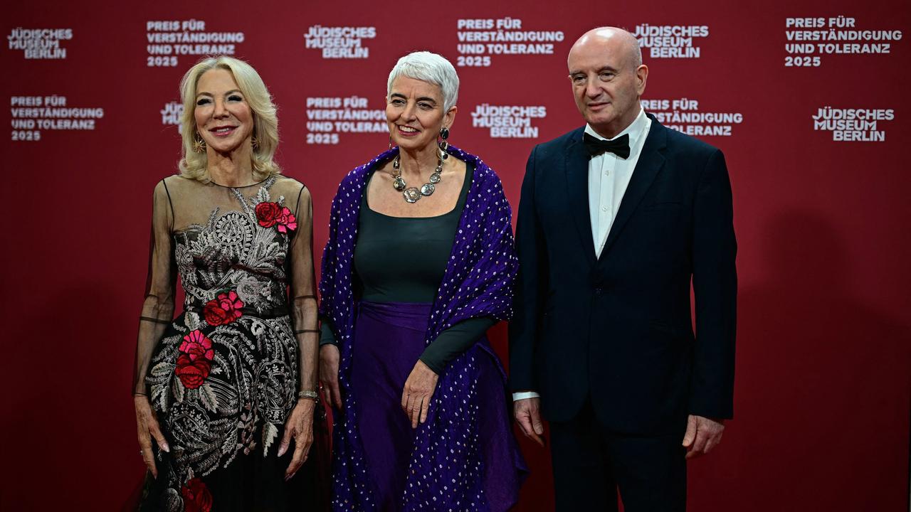 Die Direktorin des Jüdischen Museums Berlin, Hetty Berg (m.), mit den Preisträgern Amy Gutmann (l.) und Daniel Zajfman (r.); sie stehen in Abendgarderobe nebeneinander auf einer Bühne. 