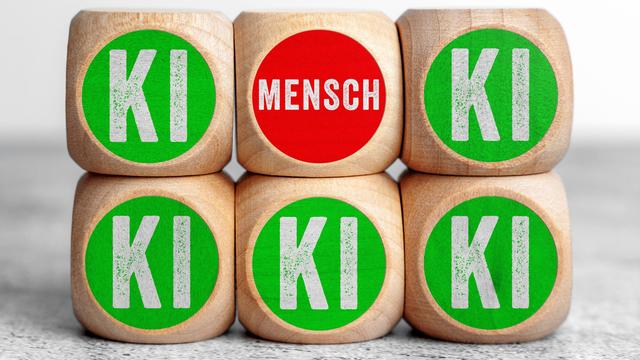 Holzwürfel mit der Aufschrift Mensch und KI symbolisieren den Gegensatz und die Beziehung zwischen menschlicher Verantwortung und künstlicher Intelligenz in einer digitalen Zukunft.