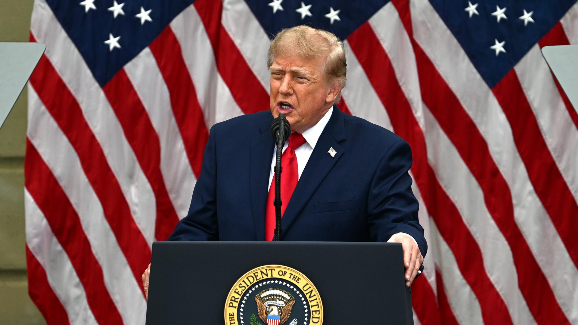 Donald Trump steht an einem Rednerpult, hinter ihm hängt die US-amerikanische Flagge. Donald Trump steht an einem Rednerpult, hinter ihm hängt die US-amerikanische Flagge.