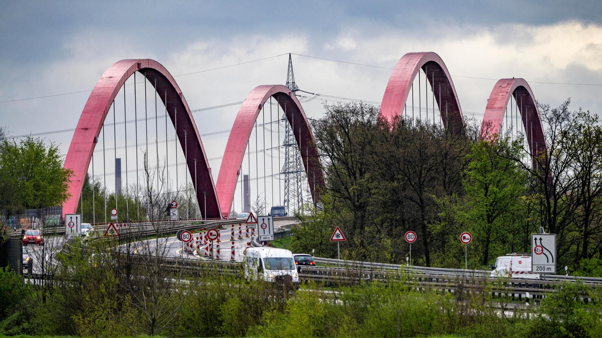 Vor einer Autobahnbrücke sind zahlreiche Verkehrsschilder aufgestellt. 