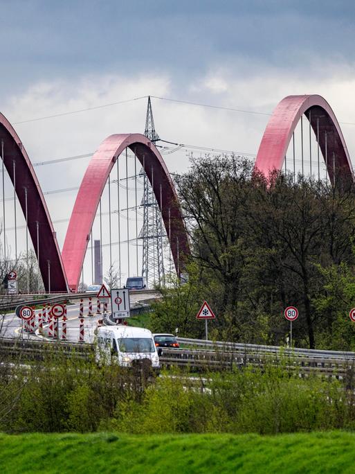 Vor einer Autobahnbrücke sind zahlreiche Verkehrsschilder aufgestellt. 