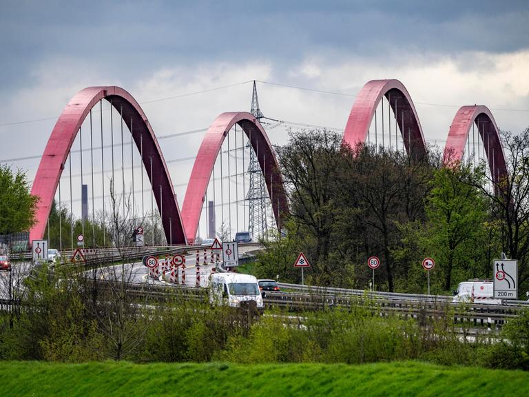 Vor einer Autobahnbrücke sind zahlreiche Verkehrsschilder aufgestellt. 