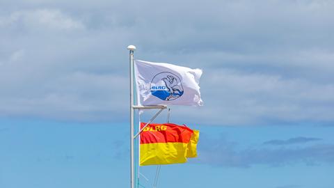 DLRG-Flaggen wehen im Wind. 