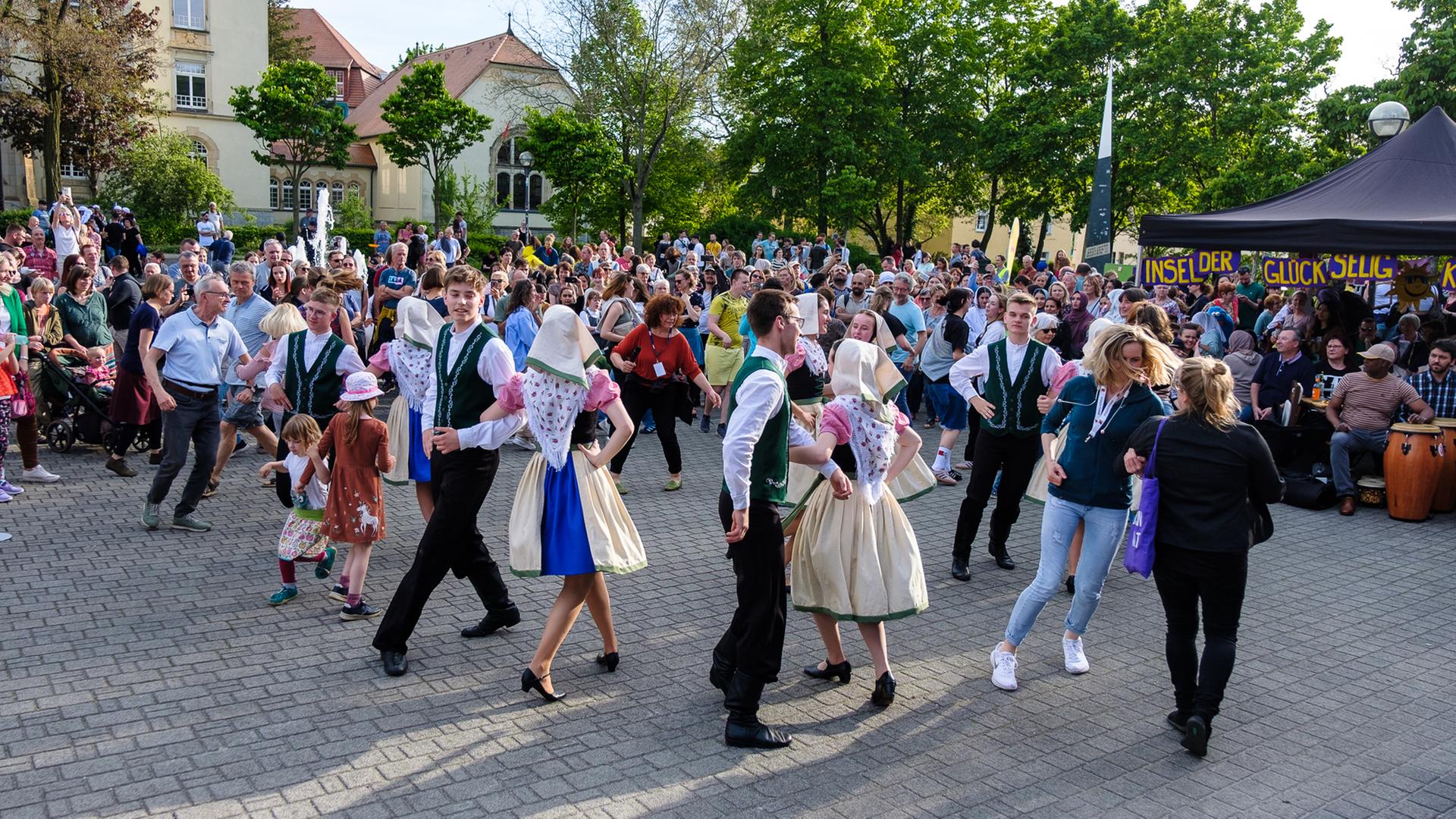 Happy Monday in Bautzen. Menschen in Trachten tanzen am 28.04.2024 unter freiem Himmel. Andere Menschen schauen zu.