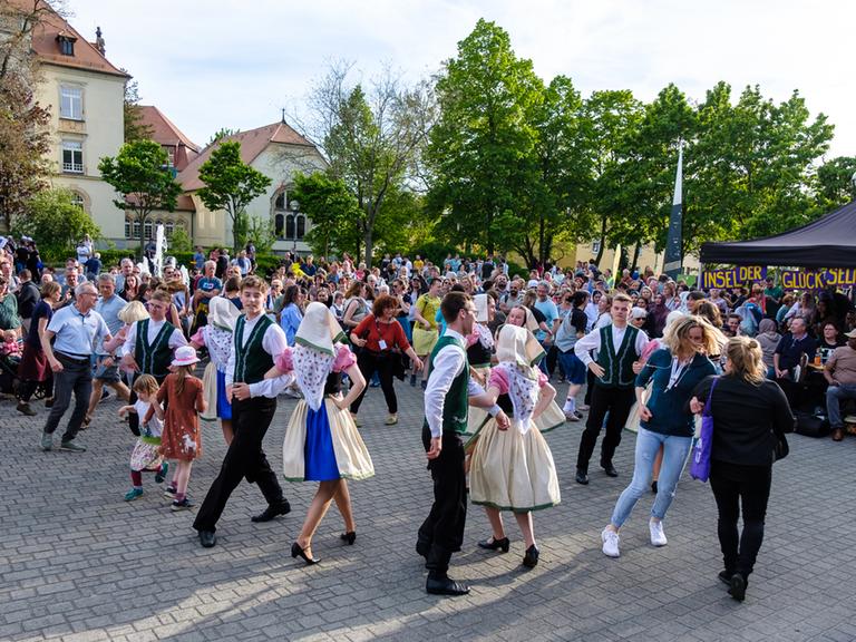 Happy Monday in Bautzen. Menschen in Trachten tanzen am 28.04.2024 unter freiem Himmel. Andere Menschen schauen zu.