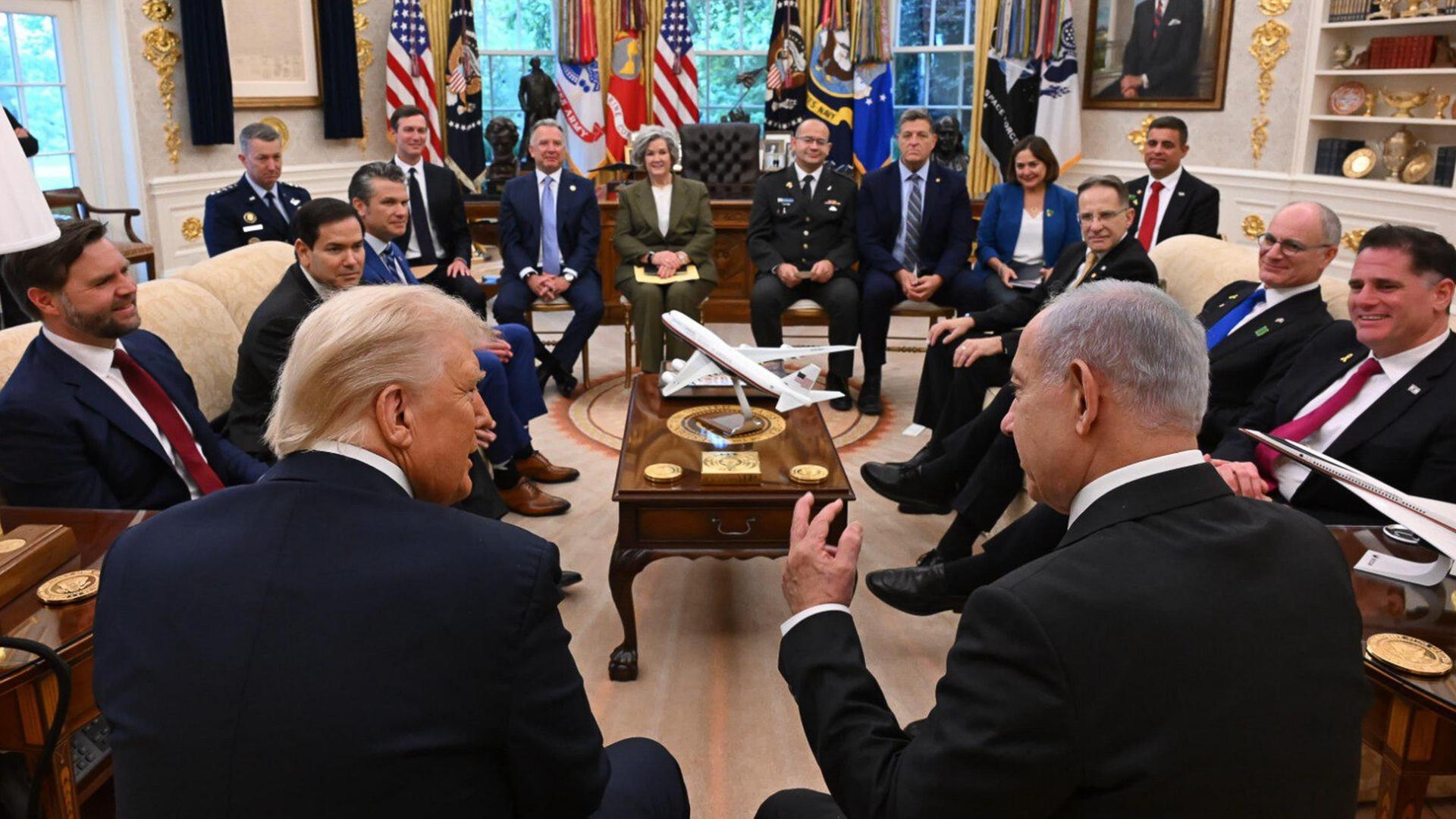 Rückenansicht von Donald Trump und Benjamin Netanjahu im Oval Office. Im Raum sitzen weiterhin ranghohe Funktionäre und Mitglieder der US-Regierung, darunter J. D. Vance