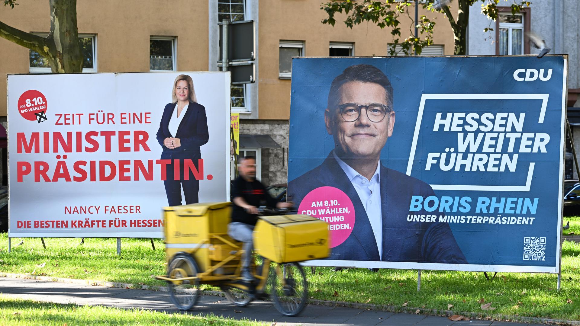 Wahlplakate der Spitzenkandidaten Boris Rhein (CDU, r), Ministerpräsident von Hessen, und Nancy Faeser (SPD), Bundesinnenministerin, stehen an einer Straße