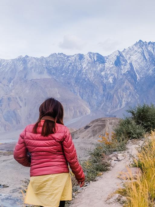 Eine Touristin wandert am Passu-Gletscher in Pakistan