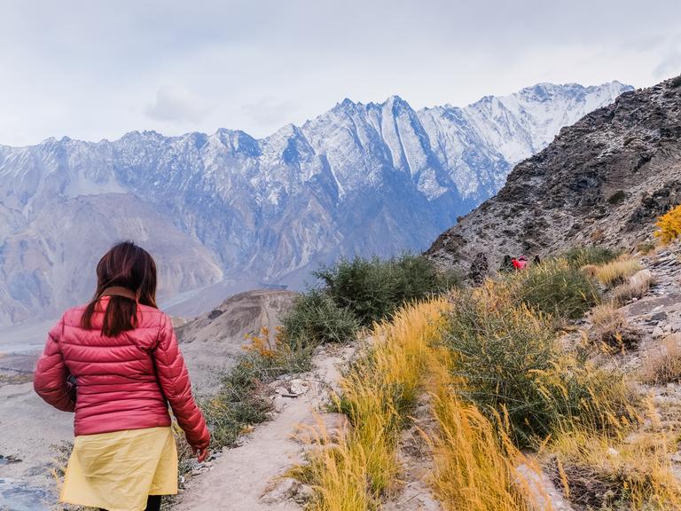 Eine Touristin wandert am Passu-Gletscher in Pakistan