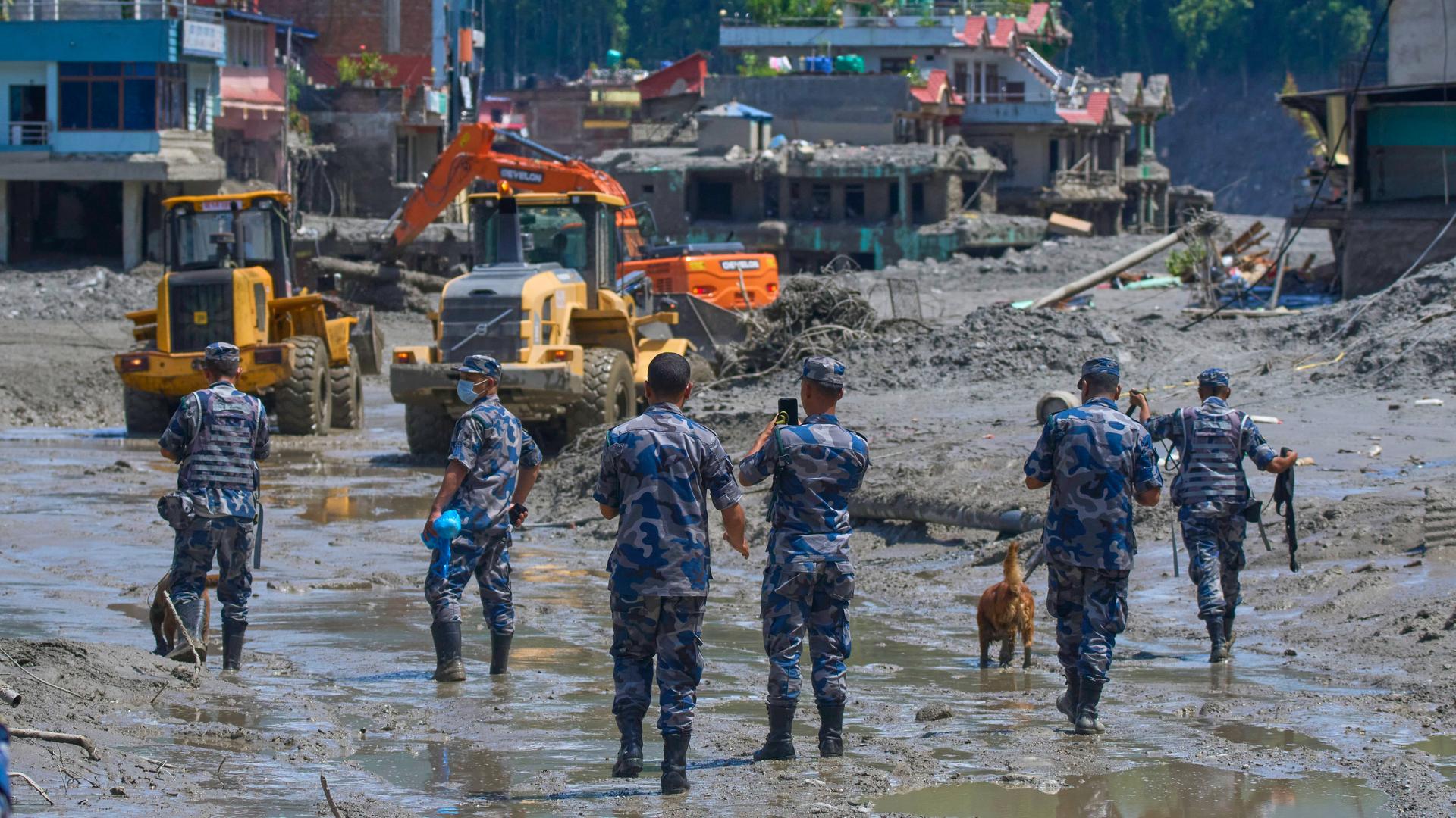 Nepalesische Polizisten beobachten, wie Bagger die Trümmer der Sturzflut im nepalesischen Distrikt Nuwakot beseitigen.
Nepalesische Polizisten beobachten, wie Bagger die Trümmer der Sturzflut im nepalesischen Distrikt Nuwakot beseitigen.