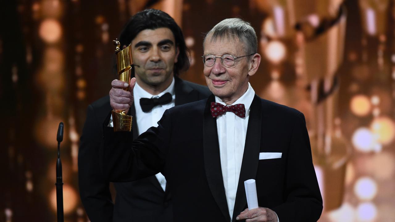 Der Filmemacher Hark Bohm streckt auf einer Veranstaltung in 2018 einen Preis in die Höhe.