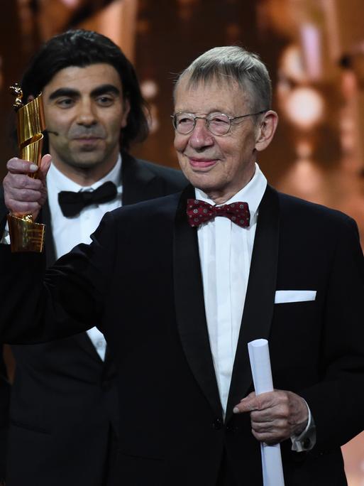 Der Filmemacher Hark Bohm streckt auf einer Veranstaltung in 2018 einen Preis in die Höhe - hinter ihm steht der Regisseur Fatih Akin.