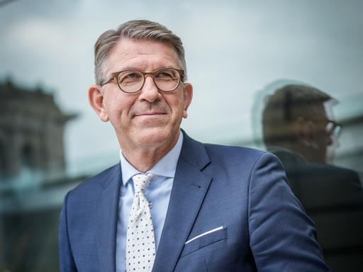 Wolfram Weimer trägt ein weißes Hemd, blaues Sakko und schaut freundlich zur Seite. 