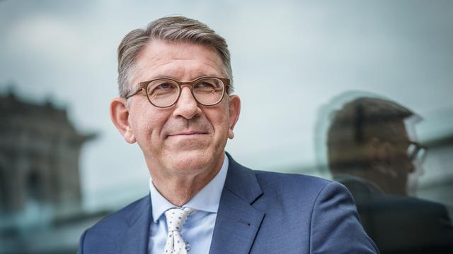 Wolfram Weimer trägt ein weißes Hemd, blaues Sakko und schaut freundlich zur Seite. 