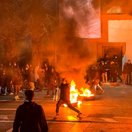 Protestierende haben eine nächtliche Straße in Teheran mit brennenden Autoreifen blockiert.