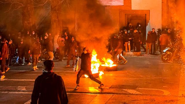 Protestierende haben eine nächtliche Straße in Teheran mit brennenden Autoreifen blockiert.