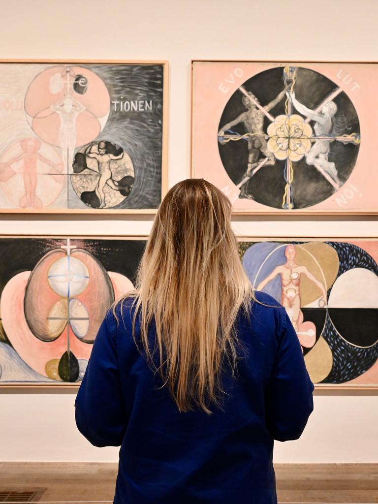 Eine Betrachterin steht vor Gemälden von Hilma af Klint in London.