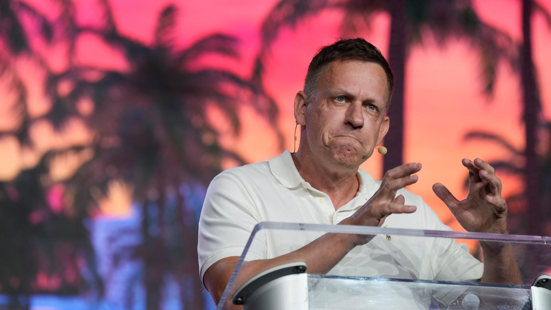 Der umstrittene Tech-Milliardär Peter Thiel steht an einem Redepult und gestikuliert mit den Händen. Der umstrittene Tech-Milliardär Peter Thiel steht an einem Redepult und gestikuliert mit den Händen.