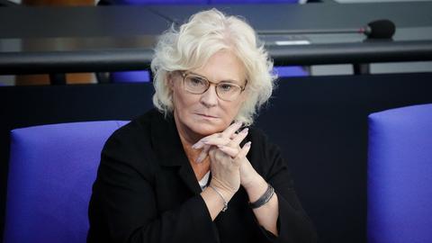Christine Lambrecht, den Kopf auf die gefalteten Hände gestützt, sitzt nachdenklich, alleine in einer Bank im Bundestag.