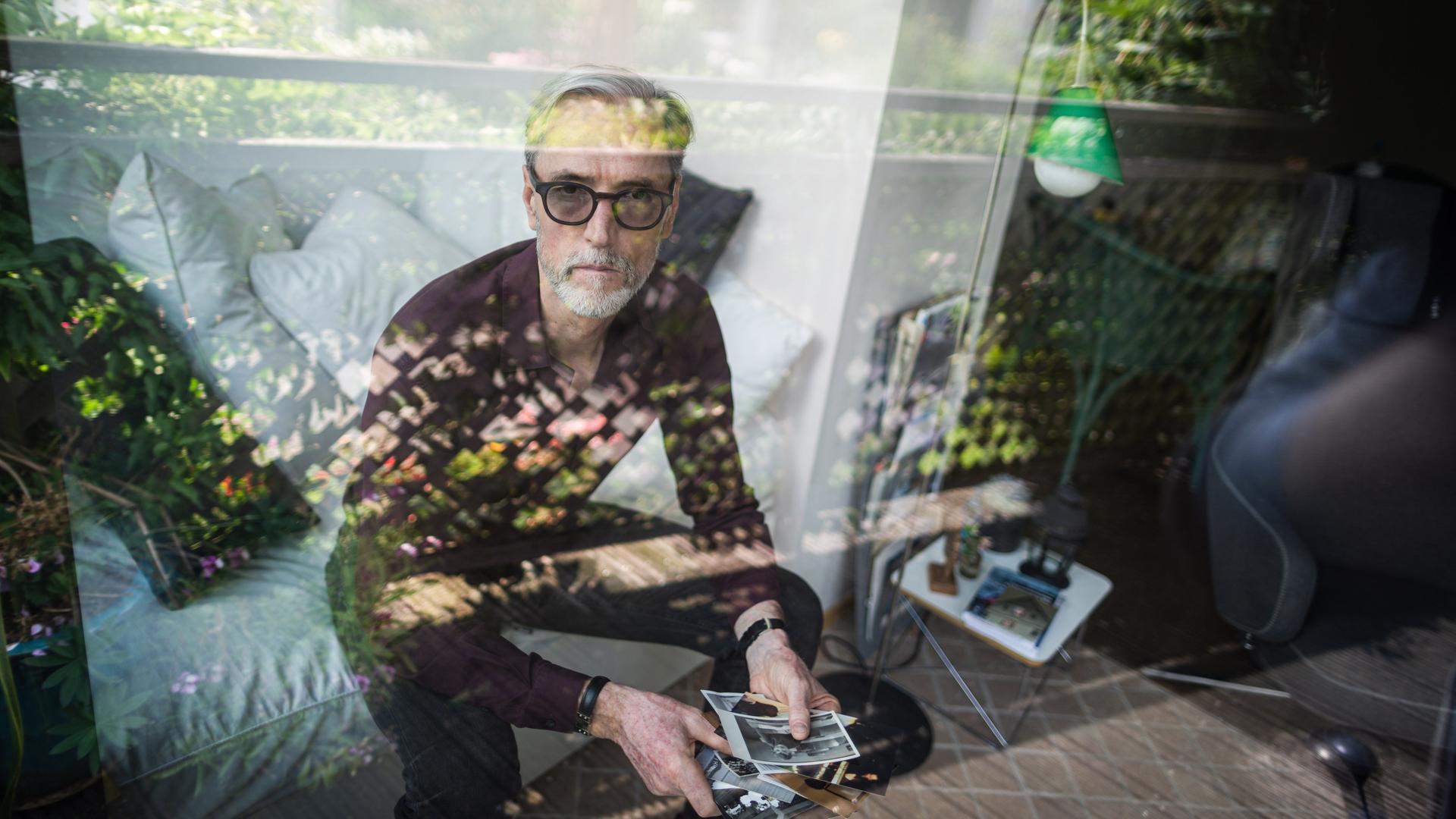 Das Porträt zeigt Peter Keup in seinem Wohnzimmer. In der Hand hält er alte Fotografien. Das Porträt zeigt Peter Keup in seinem Wohnzimmer. In der Hand hält er alte Fotografien.