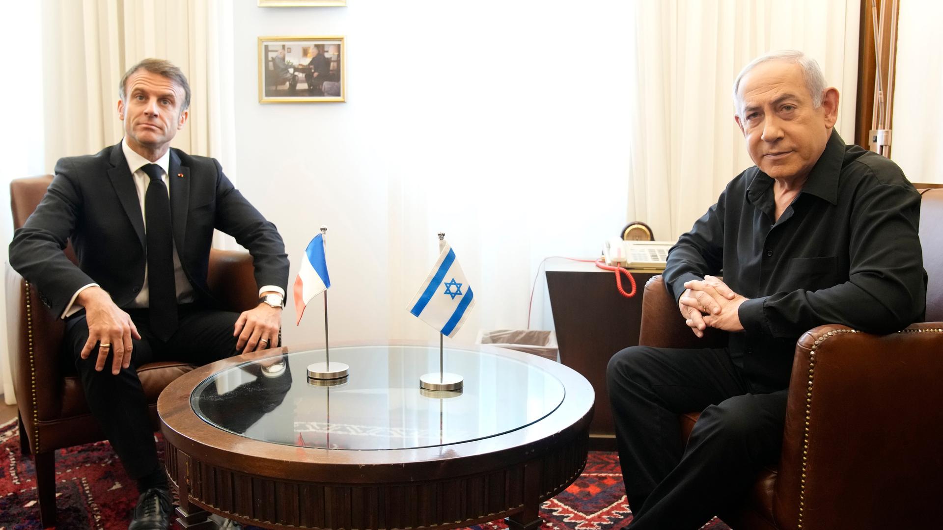Israel, Jerusalem: Benjamin Netanjahu, Ministerpräsident von Israel, sitzt neben Emmanuel Macron (l), Präsident von Frankreich, bei einem Treffen. Israel, Jerusalem: Benjamin Netanjahu, Ministerpräsident von Israel, sitzt neben Emmanuel Macron (l), Präsident von Frankreich, bei einem Treffen.