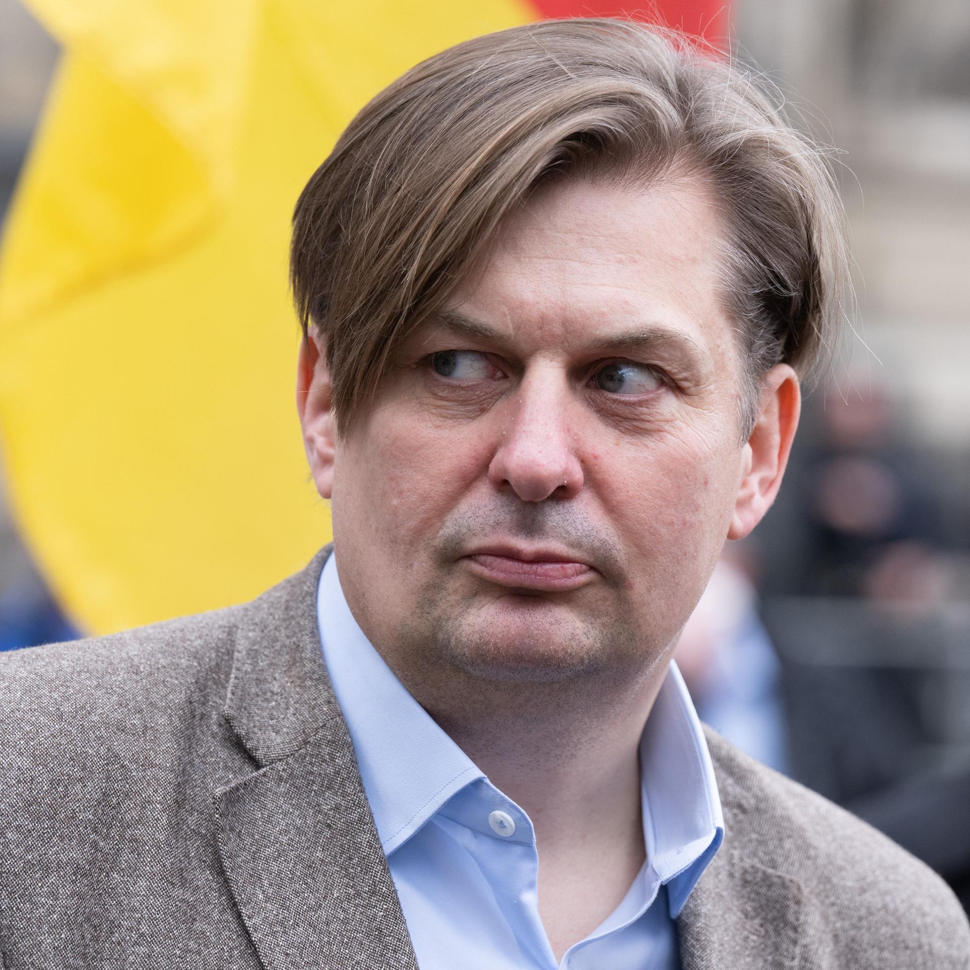 Maximilian Krah, in Sakko und offenem Hemd, nimmt an einer Kundgebung teil.