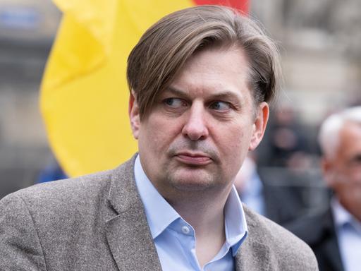 Maximilian Krah, in Sakko und offenem Hemd, nimmt an einer Kundgebung teil.