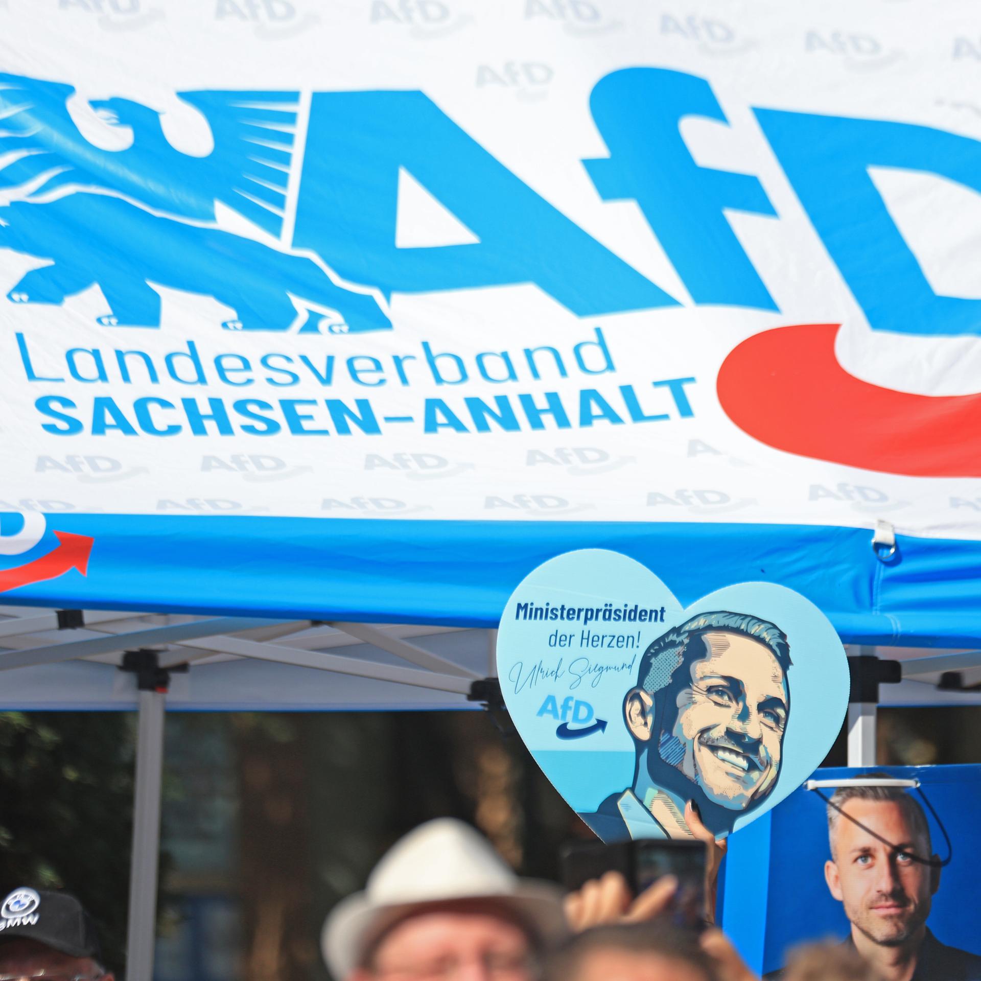 Ein Wahlwerbeschild mit dem Bild von AfD-Spitzenkandidat Siegmund ist auf einer Kundgebung der AfD zu sehen.