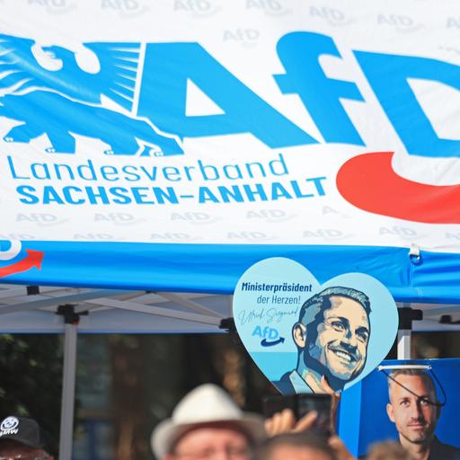 Ein Wahlwerbeschild mit dem Bild von AfD-Spitzenkandidat Siegmund ist auf einer Kundgebung der AfD zu sehen.