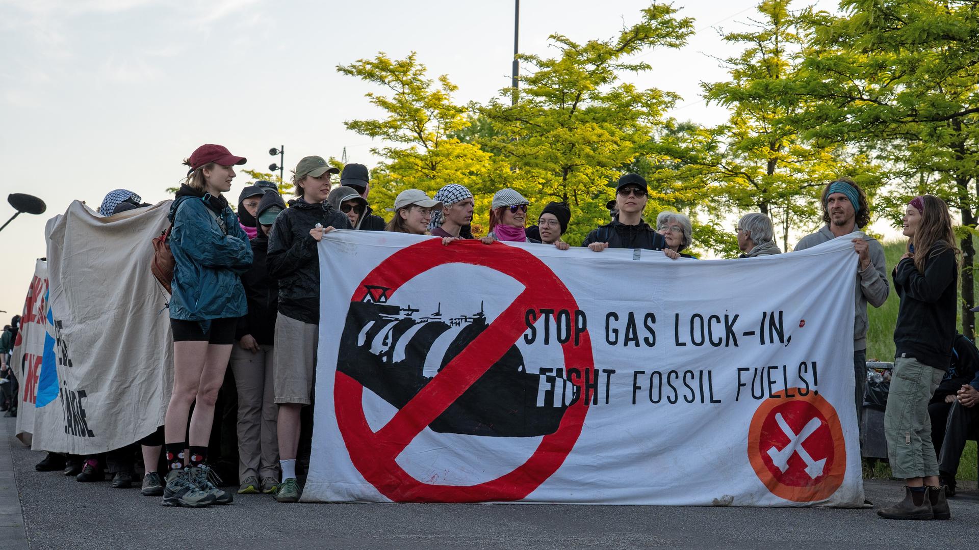 Klima-Aktivisten halten ein Protestplakat gegen den Ausbau von Gaskraftwerken. Klima-Aktivisten halten ein Protestplakat gegen den Ausbau von Gaskraftwerken.