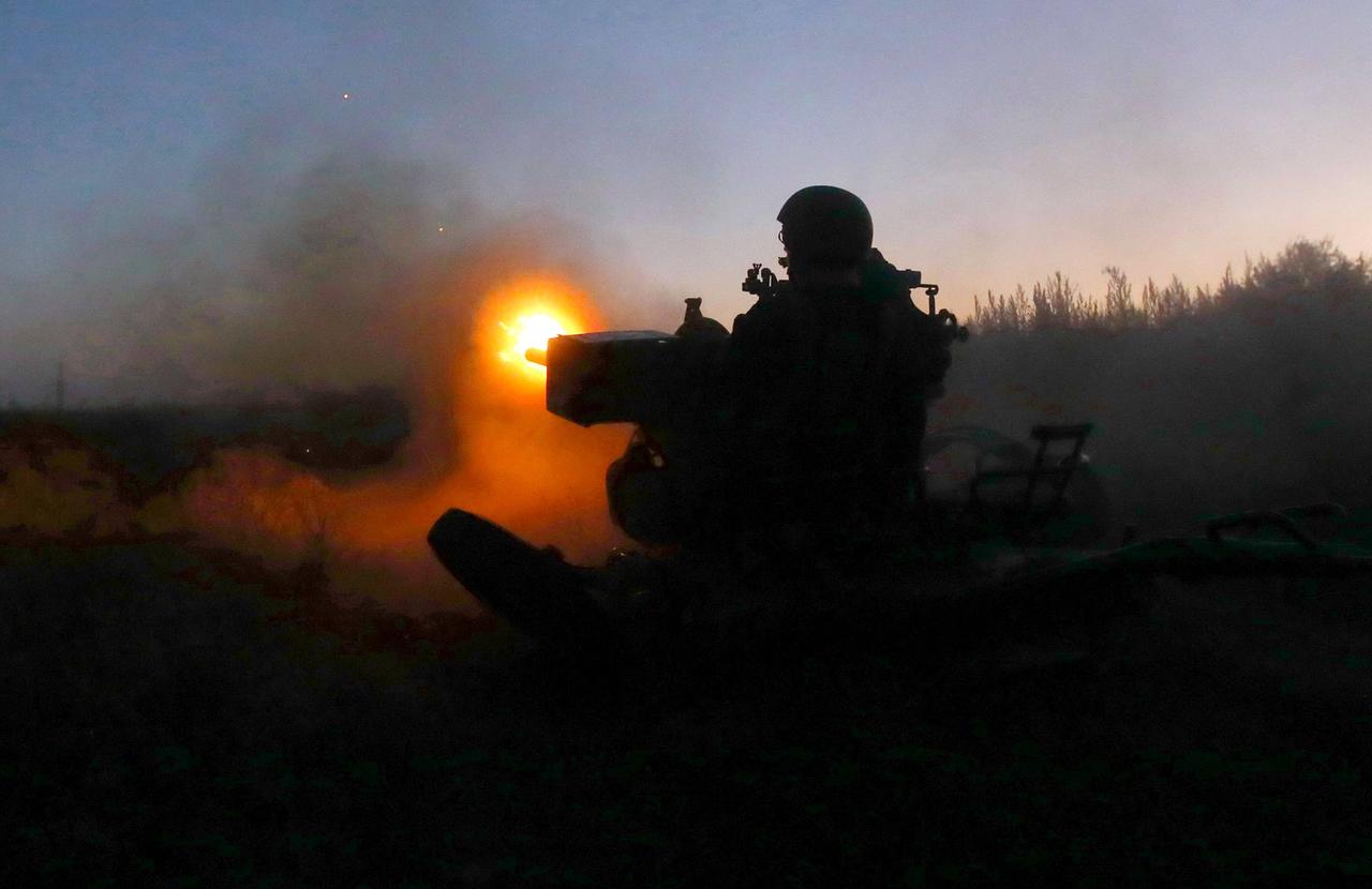 Ein Soldat feuert in der Dunkelheit eine Waffe ab.